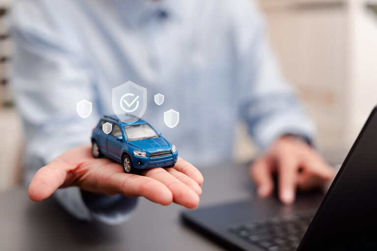 Car insurance and auto protection concept. Man holding blue toy car with shield and check mark icons for vehicle safety coverage.